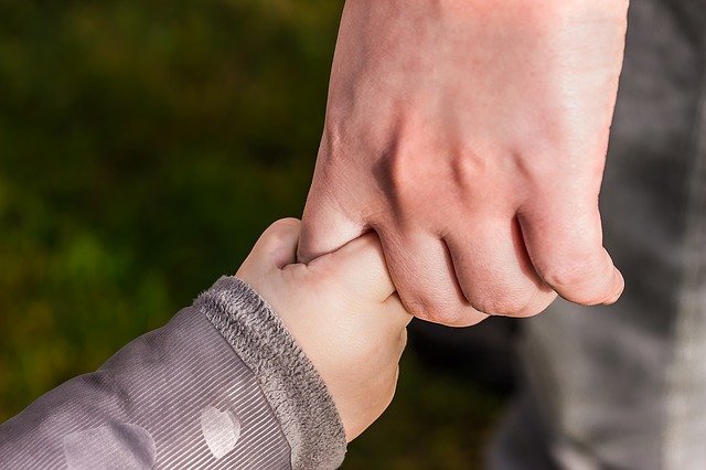 mano de un niño agarrando la mano de un adulto
